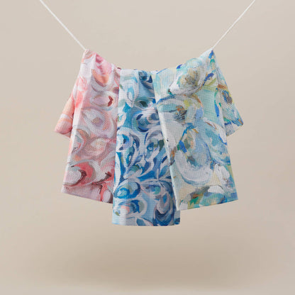 Towel with oyster design hanging on white string against beige background