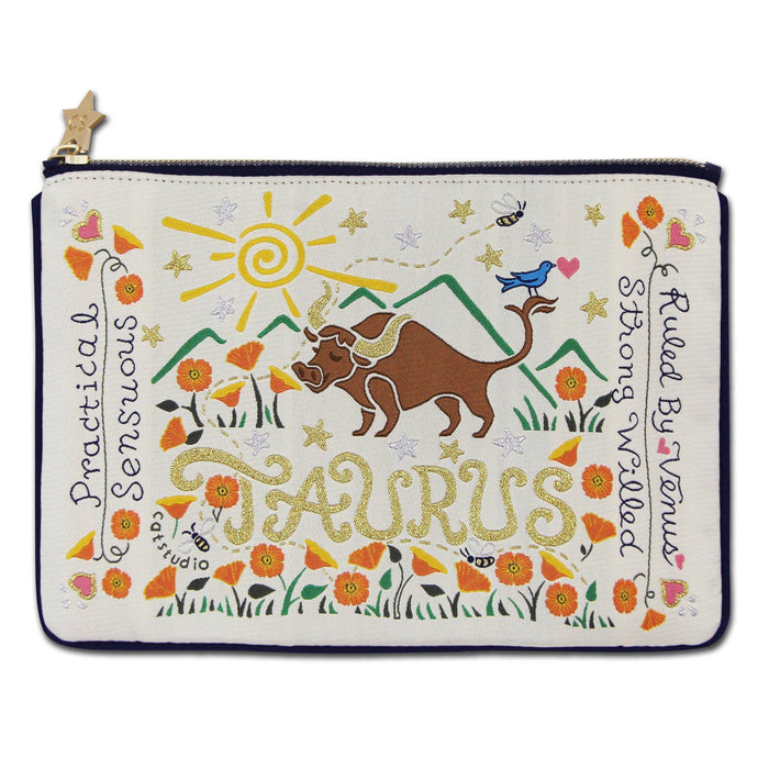 A navy-colored zip pouch with a Taurus astrology theme, featuring a graphic of a bull, flowers, and the words 'Taurus' and 'Strong-willed Taurus'.