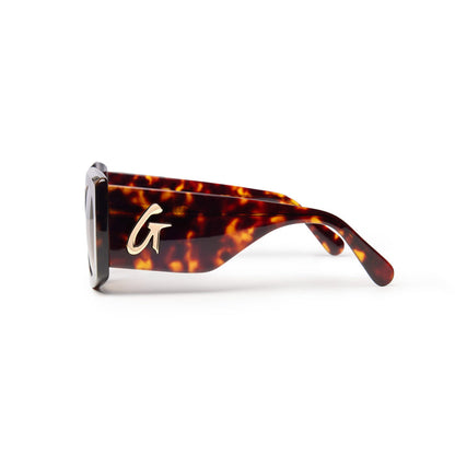 Tortoise shell sunglasses featuring a bold design and a gold logo on the side for a stylish accessory look.