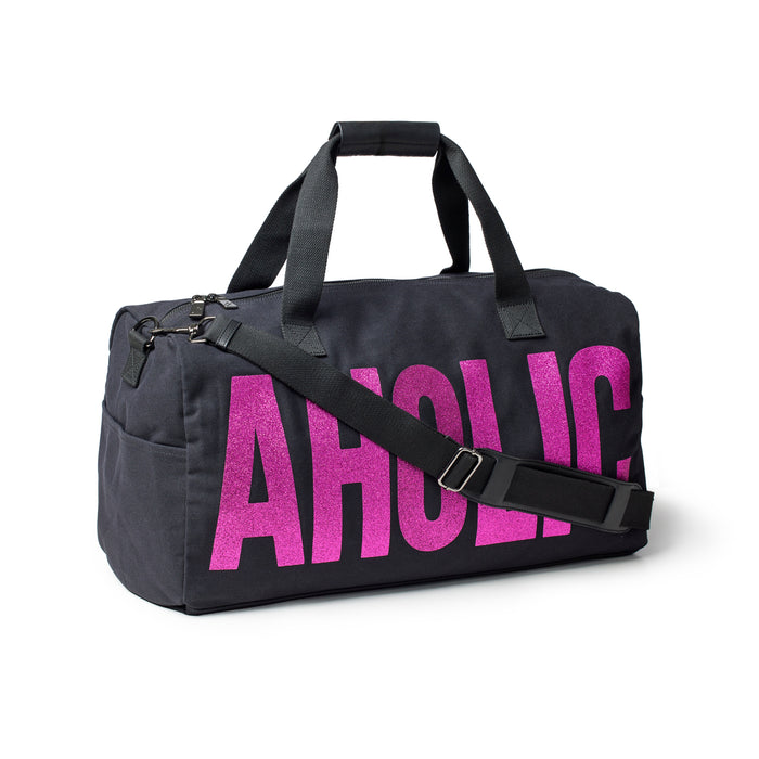Black canvas duffle bag featuring bold pink "AHOLIC" lettering, designed for stylish and practical travel.