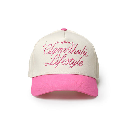 Hot pink trucker hat with white front and bold "busy living a GlamAholic Lifestyle" text. Perfect for stylish casual wear.