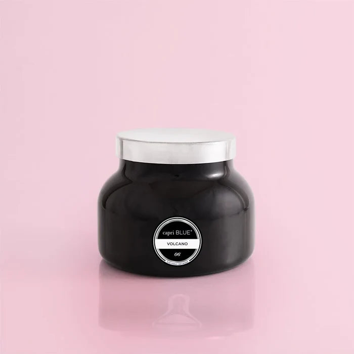 A black jar with a white lid labeled 'capri BLUE VOLCANO' on a pink background.