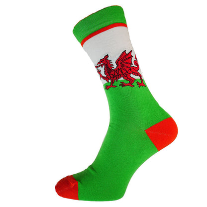 A pair of colorful socks featuring a Welsh red dragon design on a green background with a white stripe at the top, and red tips.