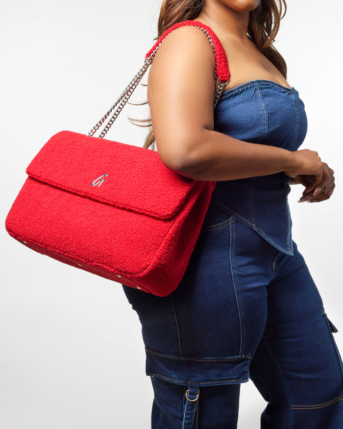 Red XL Teddy Flap Bag with a plush texture and chain strap, styled with a denim outfit for a chic look.