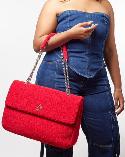 XL Teddy Flap Bag in red, featuring a plush texture and chain strap, styled with a denim outfit.